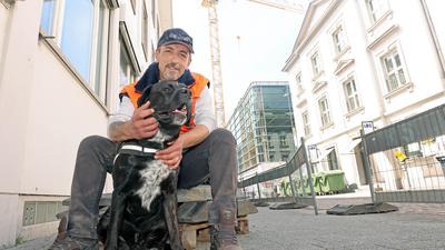 Snoopy ist der Baustellenhund bei P&C in der Kaiserstraße, sein Herrchen ist Refik Eygi, gemeinsam stehen sie vor der Baustelle in der City.