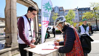 14.4.2023 Unterschriftensammlung  am Stephanplatz für den Fuß-Rad Entscheid: Bei Michael Reichert (links) und Max Bechler (hinten) setzt Gabriele Kornhas ihren Namen unter das Bürgerbegehren.