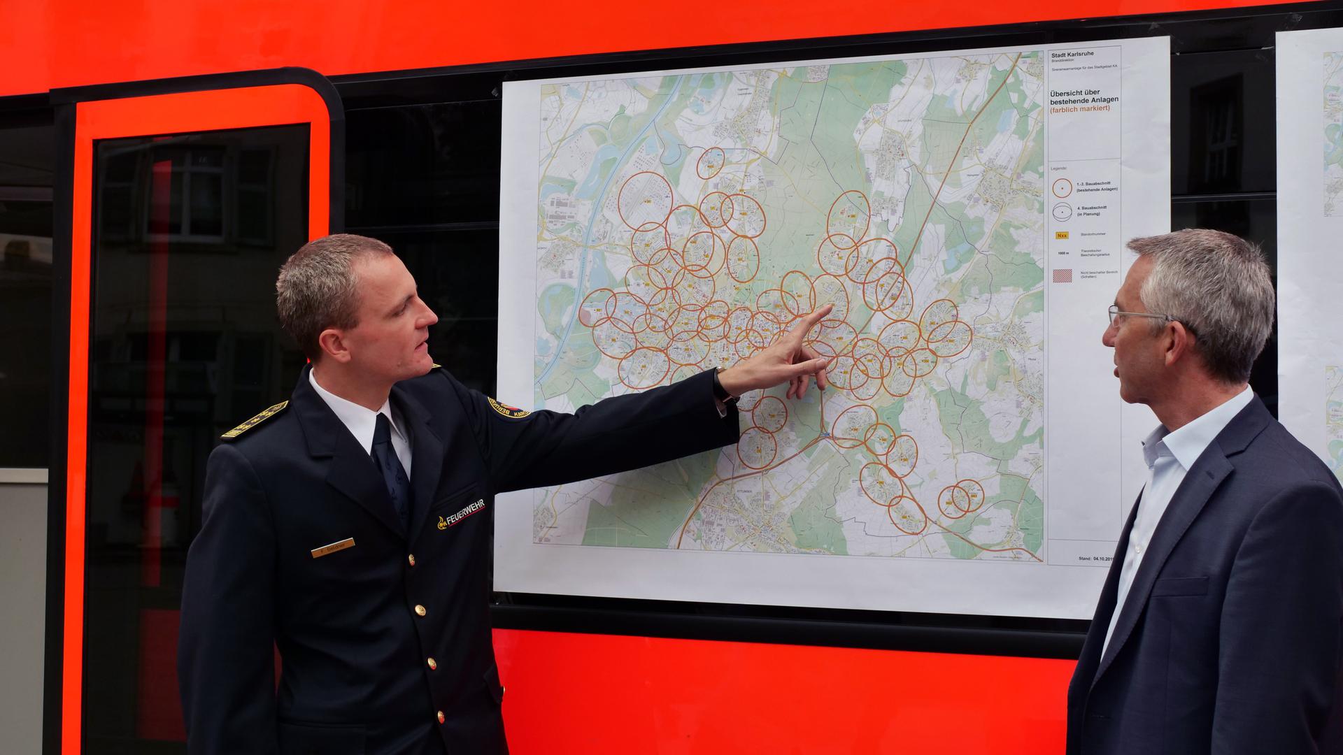 Florian Geldner zeigt Bürgermeister Lenz die Karte mit den Zonen der Warnsirenen