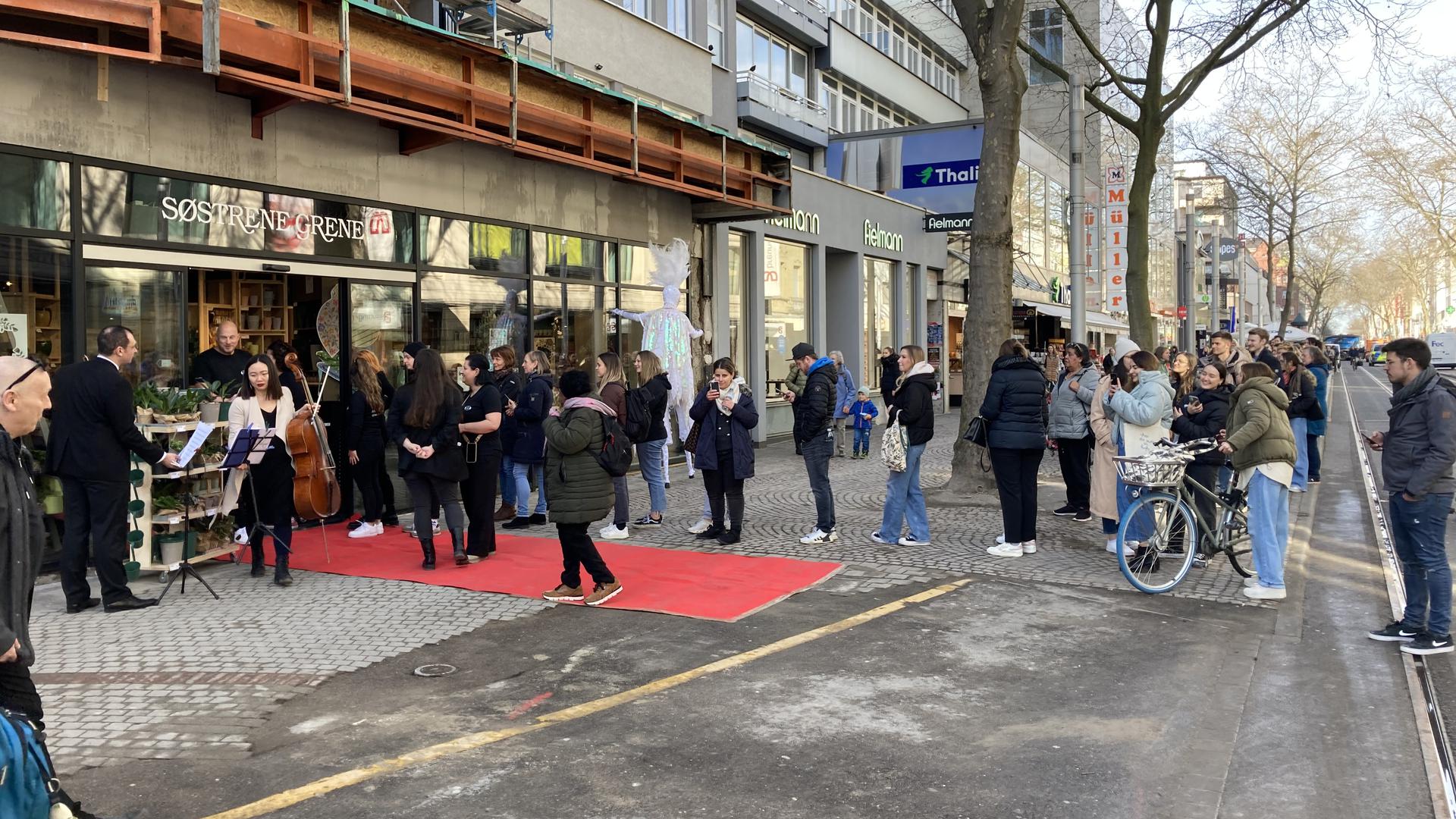 Blick auf den roten Teppich vor dem Søstrene Grene Laden in der Karlsruher Kaiserstraße sowie die Schlange vor der Tür