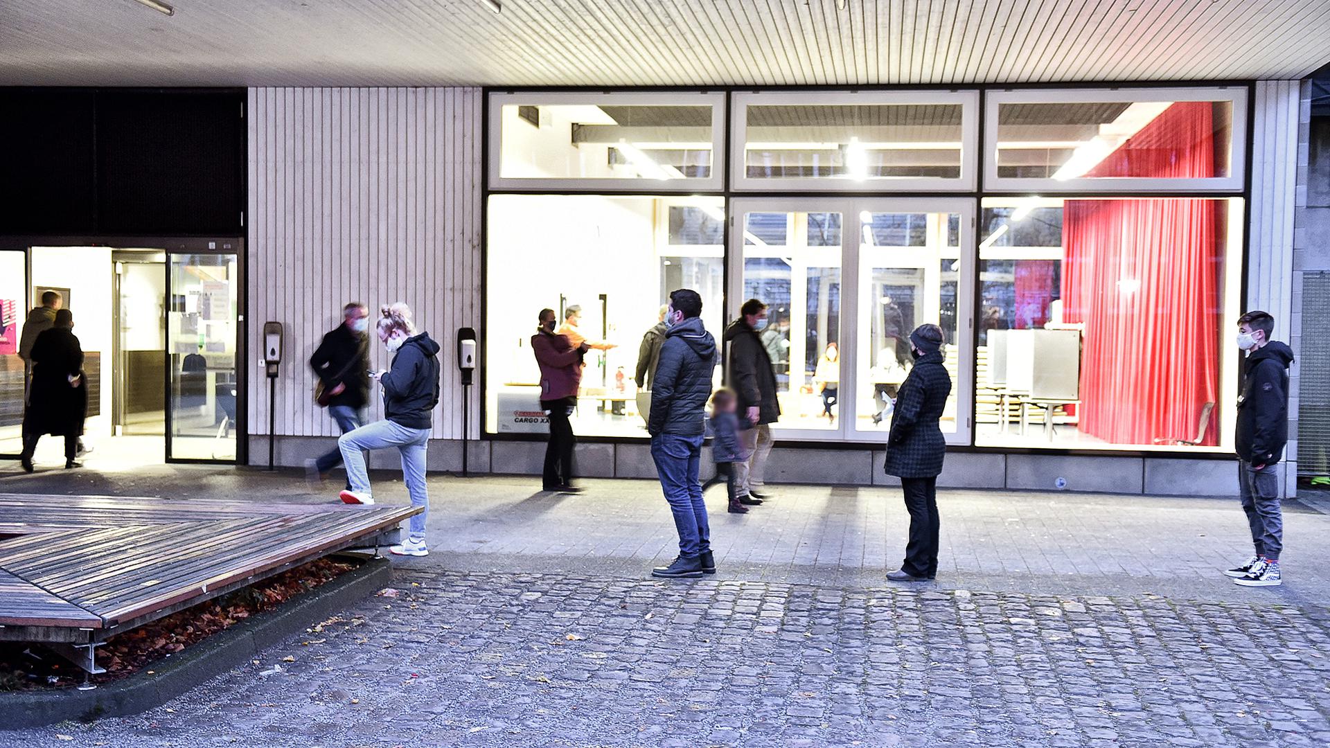 Menschen warten bei der OB-Wahl in Karlsruhe vor dem Wahllokal Goethe-Gymnasium.