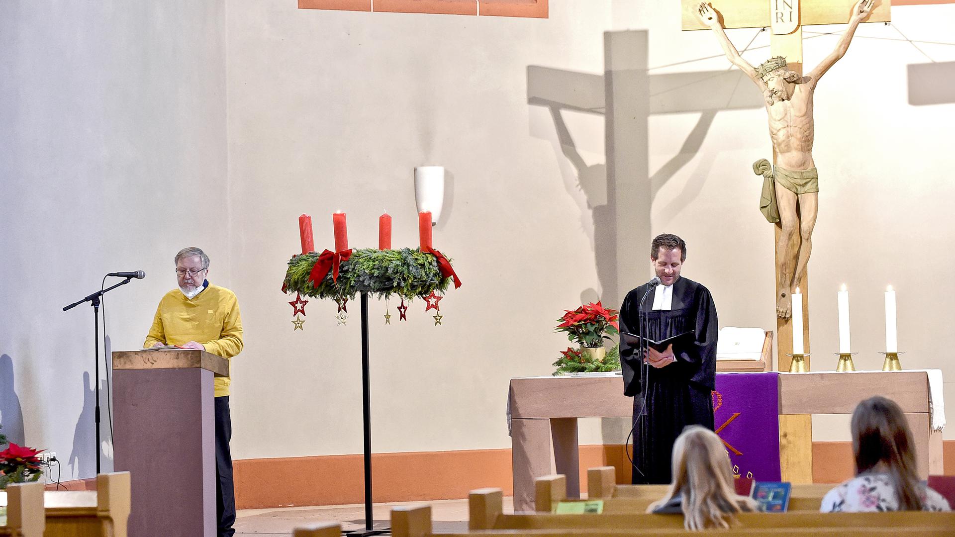 Zwei Männer stehen stehen in einer Kirche am Mikrofon.