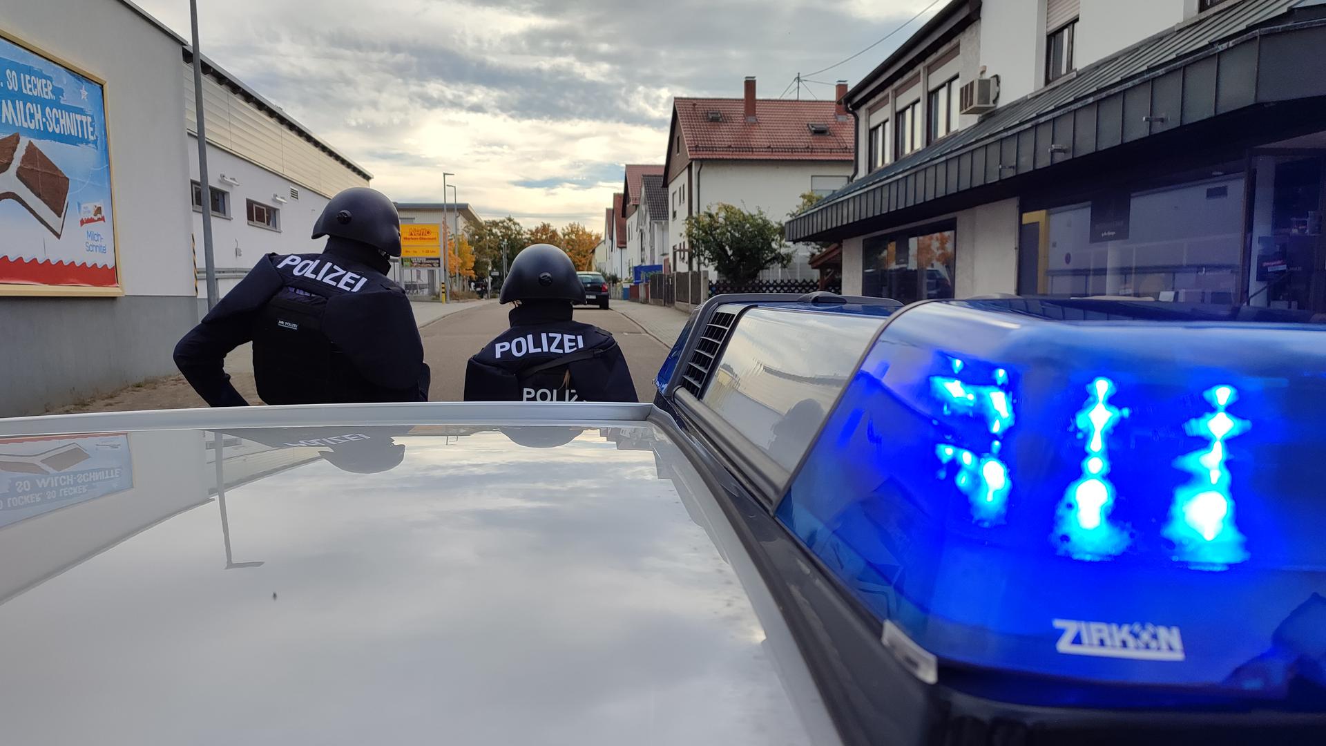 Polizisten mit Helmen stehen in Karlsruhe-Neureut. Dort hat es einen Großeinsatz gegeben.