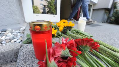 Vor einem Hauseingang im Stadtteil Nordstadt in Karlsruhe liegen am Donnerstag (05.07.2012) Blumen. Bei einer Zwangsräumung in dem Haus ist es am Mittwoch (04.07.2012) zu einer Schießerei mit einer Geiselnahme gekommen. Dabei hat es fünf Tote gegeben. Foto: Uli Deck dpa/lsw ++ +++ dpa-Bildfunk +++