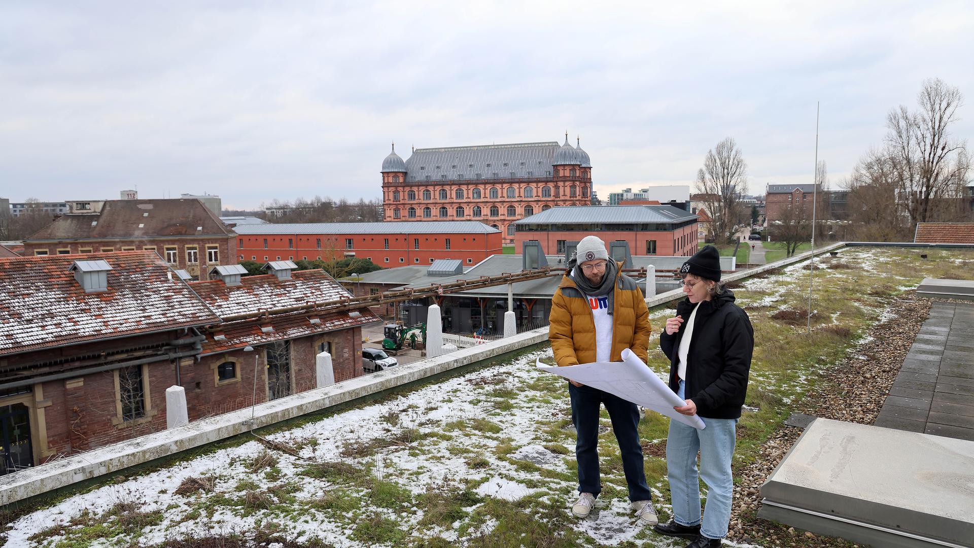 Zwei Menschen stehen auf dem Dach des Substage über den Dächern des Karlsruher Schlachthofs.