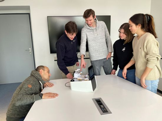 Blick aufs Innenleben: Dario Mager vom KIT lässt sich von den Studierenden Nicklas Rondot (von links), Leon Middendorf, Johanna Bartl und Alina Stein ihr PCR-Testgerät erklären.