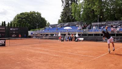 Auf einem Tennisplatz in Karlsruhe-Rüppurr spielen zwei Männer Tennis. Hinter ihnen ist eine Tribüne zu sehen. Diese war bislang auf der Sonnenseite des Platzes installiert, wo die Sitzschalen allerdings in den Mittagsstunden oft so heiß wurden, dass man kaum darauf sitzen konnte. 