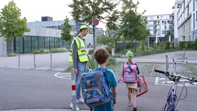Schülerlotse Marcel Krenz hilft Kindern an der Grundschule am Wasserturm in der Karlsruher Südstadt über die Straße.