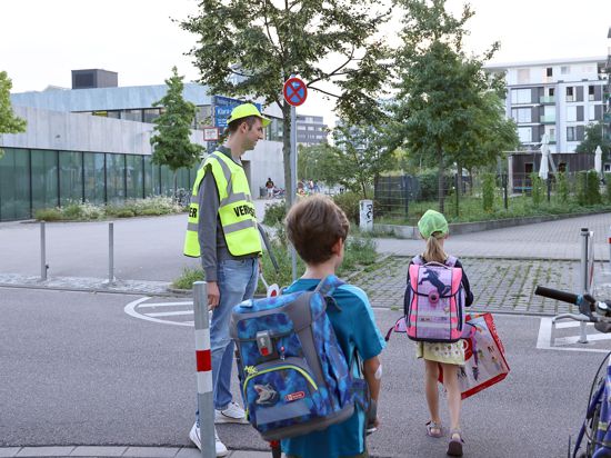 Schülerlotse Marcel Krenz hilft Kindern an der Grundschule am Wasserturm in der Karlsruher Südstadt über die Straße.