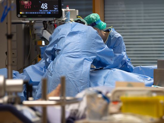 Enormer Aufwand: Medizinisches Personal legt auf einer Intensivstation einem Covid-19-Patienten einen Zugang für die künstliche Beatmung.