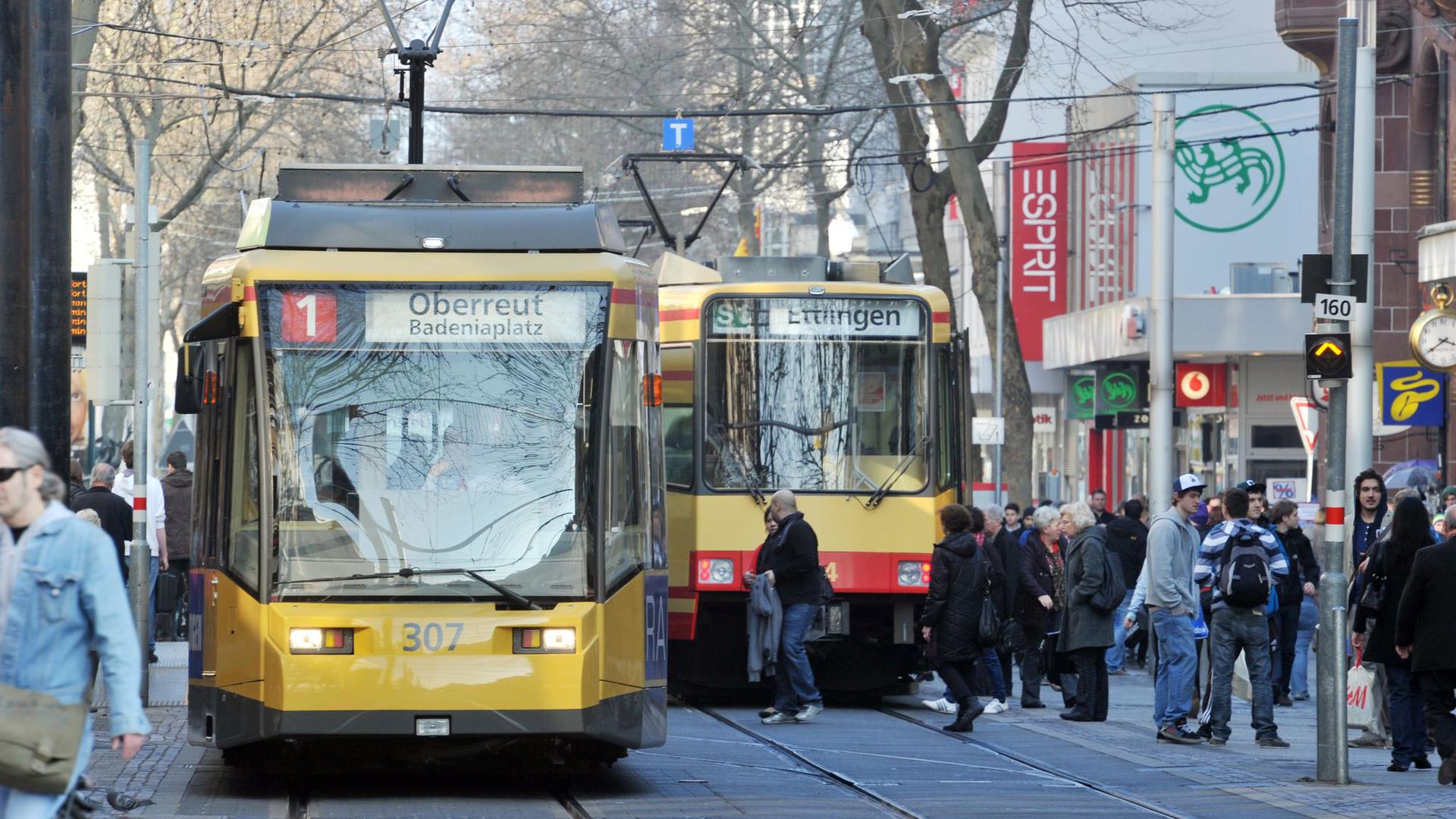 Straßenbahnen fahren durch die Fußgängerzone in der Karlsruher Innenstadt.