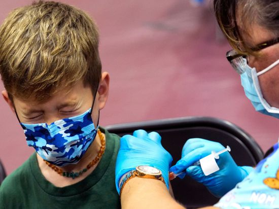 Ein Junge in den USA kneift während seiner Impfung die Augen zusammen. Nun könnte auch die EMA den Impfstoff empfehlen.