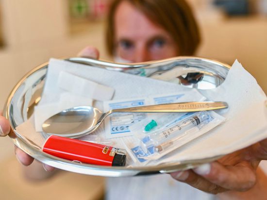 Der 49-Jährige Drogenkonsument Uli zeigt im Drogenkonsumraum eine Schale, in der sich Utensilien für den intravenösen Drogenkonsum befinden. 