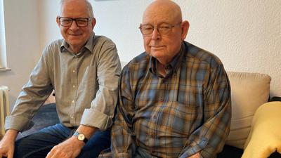 Günter Walter (links) und Roy Gilkey (rechts) sitzen auf einem Sofa.