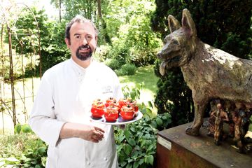 Koch präsentiert Teller mit gefüllten Tomaten