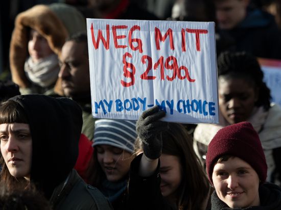 08.03.2019, Berlin: Teilnehmer einer Demonstration zum Internationalen Frauentag gehen durch Mitte und halten dabei ein Schild mit der Aufschrift «Weg mit Paragraf 219a - My Body - my Choice». Foto: Ralf Hirschberger/dpa +++ dpa-Bildfunk +++