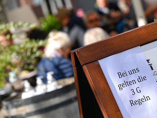Vor dem Café Hauptwache in der Frankfurter Innenstadt ist eine Tafel mit der Aufschrift «Bei uns gelten die 3 G Regeln» aufgestellt. Rund eine Woche nach dem Start des 2G-Optionsmodells bei den hessischen Corona-Regeln ziehen Gastgewerbe und Friseure ein durchweg positives Resümee. (zu dpa «2G-Regeln: Gastgewerbe und Friseure sehen neue Vorgaben positiv») +++ dpa-Bildfunk +++