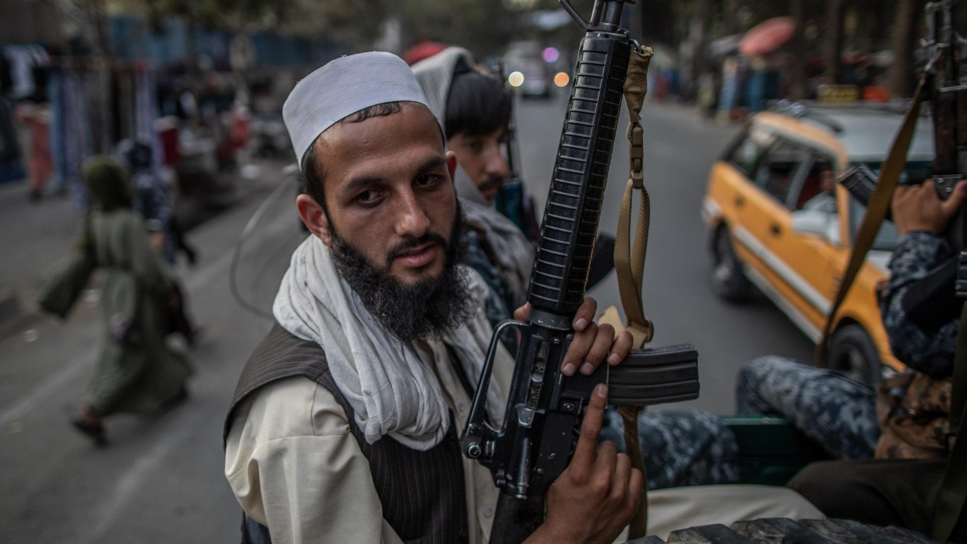 Junge Taliban-Kämpfer patrouillieren auf der Ladefläche eines Pick-Ups in den Straßen von Kabul. Die Taliban wollen in Afghanistan ein funktionierendes Staatswesen auf die Beine stellen. In Kabul haben ihre Kämpfer die Aufgaben der Polizei übernommen. (Zu dpa-Korr "Kabul nach dem Fall: Taliban-Kämpfer in der deutschen Polizeiwache") +++ dpa-Bildfunk +++