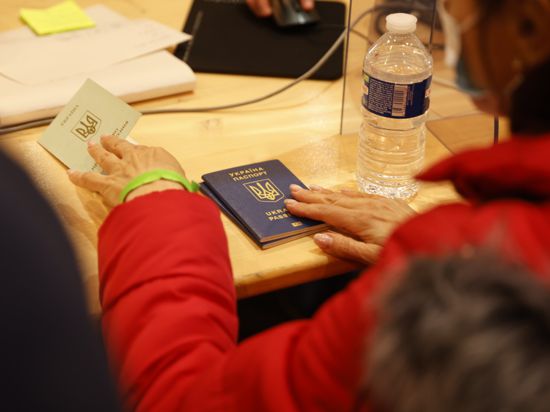 Eine Person hält ihren ukrainischen Reisepass in der Hand, als sie sich in der Halle Palace 8 der Brüsseler Expo in einem Registrierungszentrum anmeldet. Die Regierung von Belgien hat das Zentrum eröffnet, um Ukrainern, die vor der russischen Invasion aus ihrem Land geflohen sind, die Registrierung zu ermöglichen. +++ dpa-Bildfunk +++