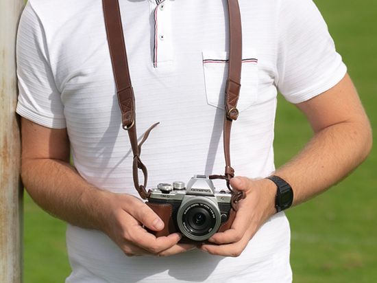Ein Fotograf hält eine Fotokamera.