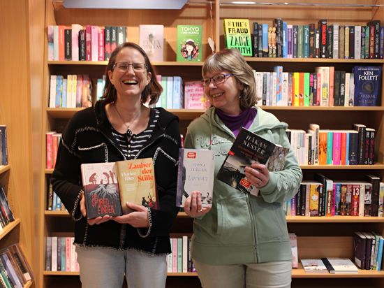 Filialleiterin Christine Kemmet und Verkäuferin Karen Maier (von links nach rechts) von der Bücher-Oase Stutensee zeigen beliebte Bücher.