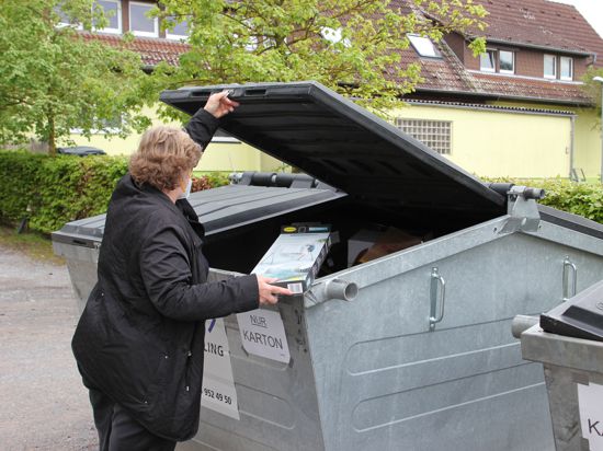 weibliche Person beim Öffnen einer Mülltonne