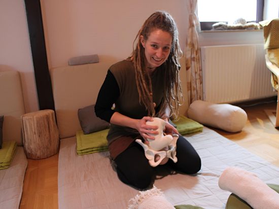 HypnoBirthing-Kursleiterin Romina Nickel zeigt mithilfe einer Puppe und eines Beckenmodells die Lage des Babys bei der Geburt. 
