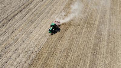 Ein Bauer eggt mit seinem Traktor ein abgeerntetes Getreidefeld. (Luftaufnahme mit einer Drohne). +++ dpa-Bildfunk +++