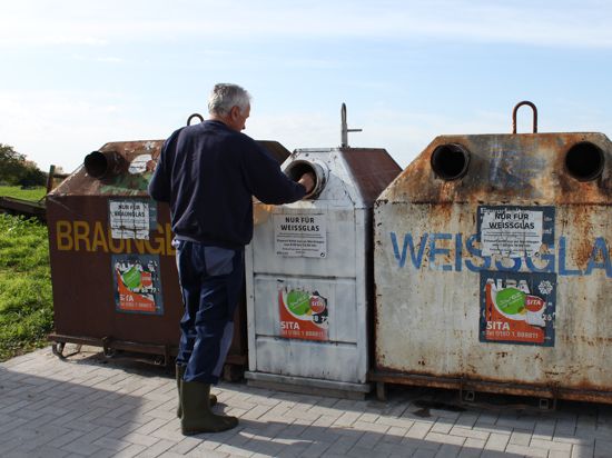Ein Mann entsorgt Altglas an einem Container in Dettenheim