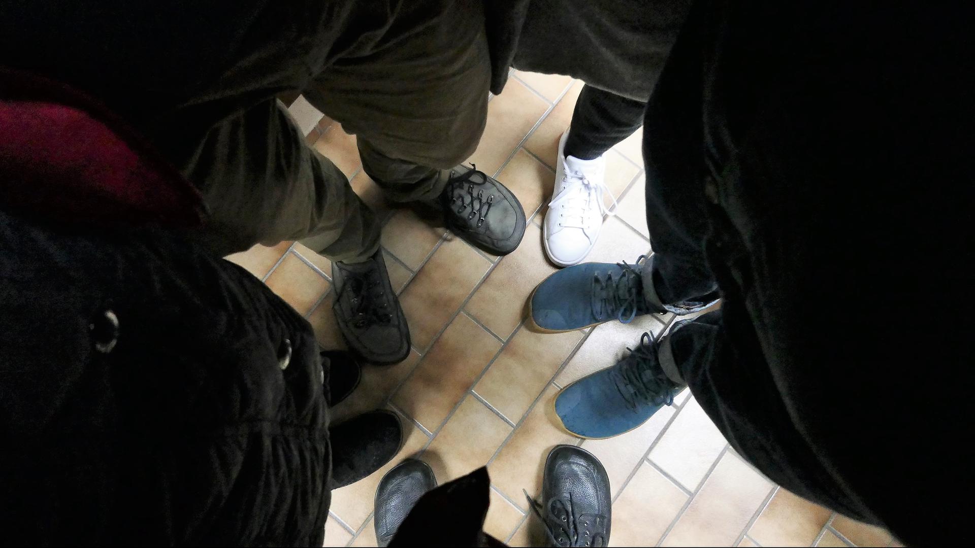 Füße von schwarz gekleideten Menschen.