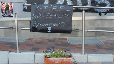 Vor der Flora-Apotheke in Eggenstein steht beim Apotheken-Protesttag ein Blumenkübel mit Stiefmütterchen und ein Schild mit der Aufschrift „Stiefmütterlich behandelt“. 