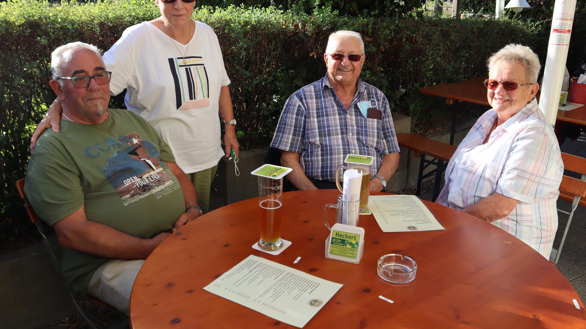 Zwei Männer und zwei Frauen an Tisch in Biergarten
