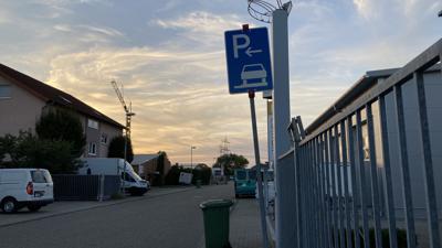 Ein blau-weißes Schild weist im Eggensteiner Junkersring auf das Gehwegparken auf einer Straßenseite hin. 