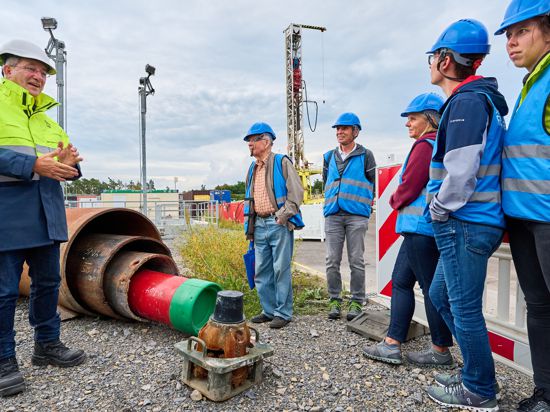 Roman Link und die Teilnehmer der Sommertour stehen auf der Baustelle des Geothemie-Kraftwerks.