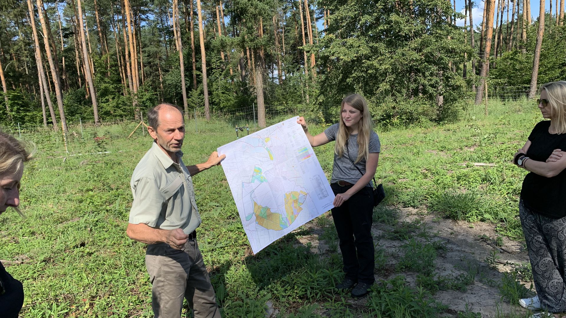 Mann und Frau zeigen Karte im Wald