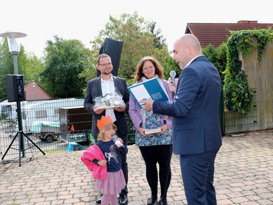 Bürgermeister Christian Eheim gratuliert Katja und Micha Willunat zur Übernahme der Pfarrstelle mit Henhöferhaus und überreicht ein Buch über Graben-Neudorf