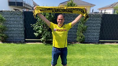 Timo Johannes hält im Borussia-Trikot einen Fan-Schal in die Höhe. 