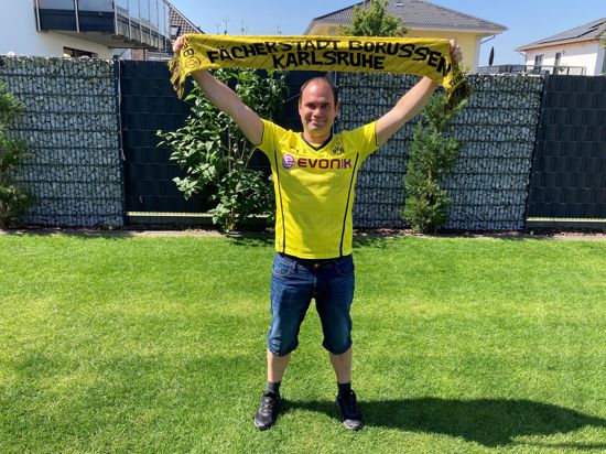 Timo Johannes hält im Borussia-Trikot einen Fan-Schal in die Höhe. 