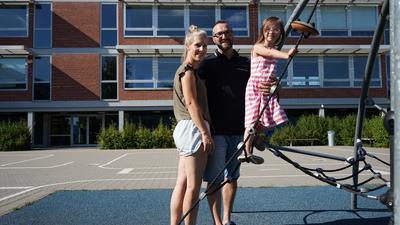 Möchte gerne hier zur Schule gehen: Ida, zusammen mit ihren Eltern Thorsten und Simone Jahraus, auf dem Pausenhof der GWRS Linkenheim.