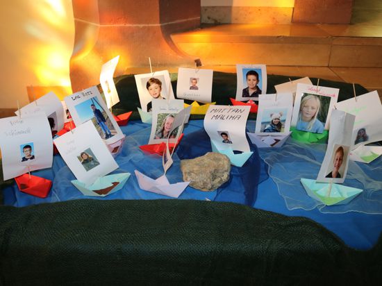 Fotos von Kommunionskindern mit Papierschiffen und Kerzen