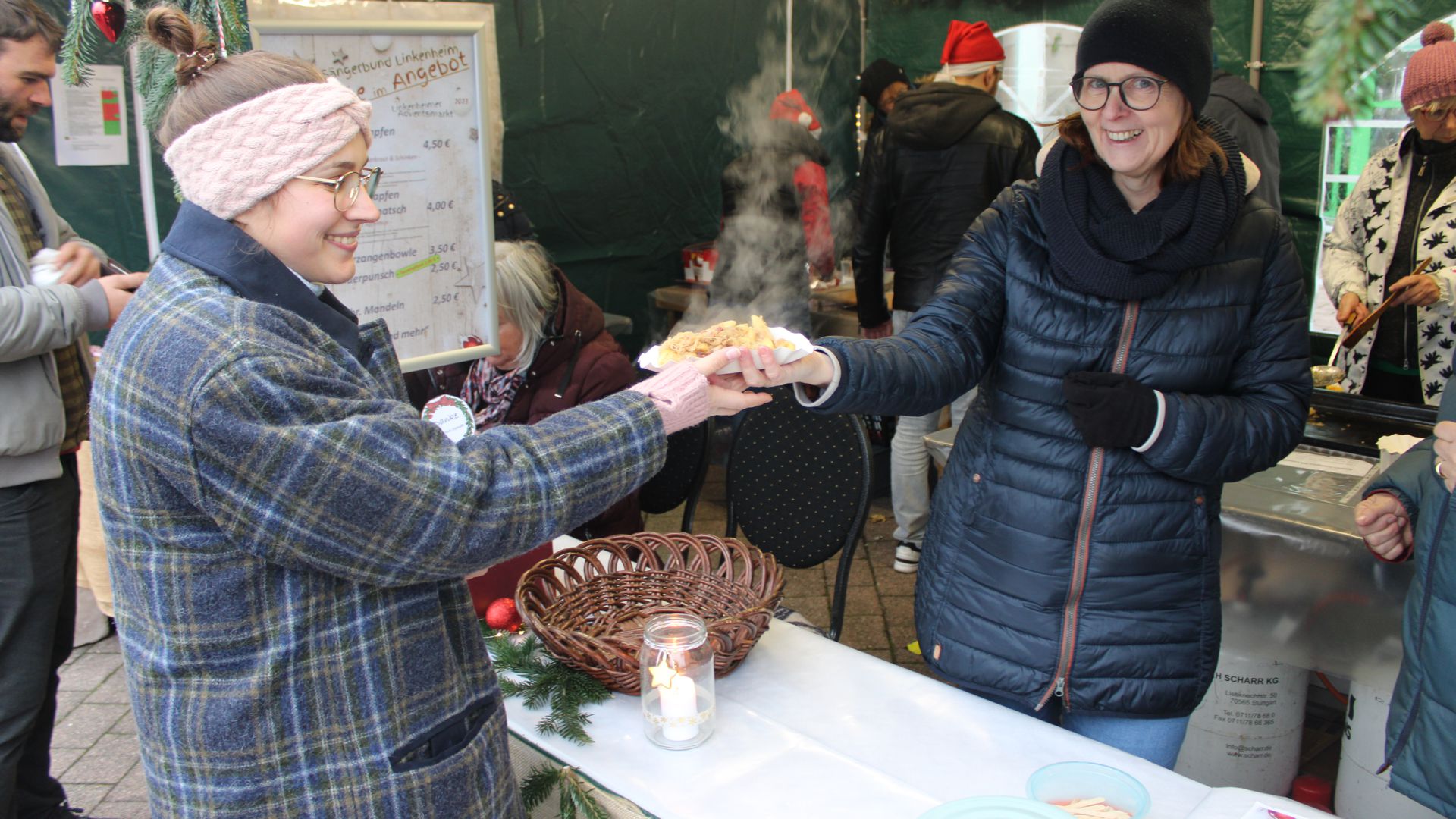 Auf dem Weihnachtsmarkt in Linkenheim-Hochstetten verteilt Carmen Dahring (rechts) vom Gesangverein Sängerbund eine Portion Sauerkraut mit Schupfnudeln.
