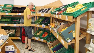 Ein Mann im gelben Shirt kauft Gemüse ein