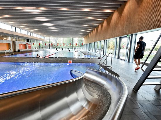 Schwimmbecken im Hallenbad Stutensee mit Badegästen, rechts der Schwimmmeister Marco Schlimm, der das Schwimmen beaufsichtigt.