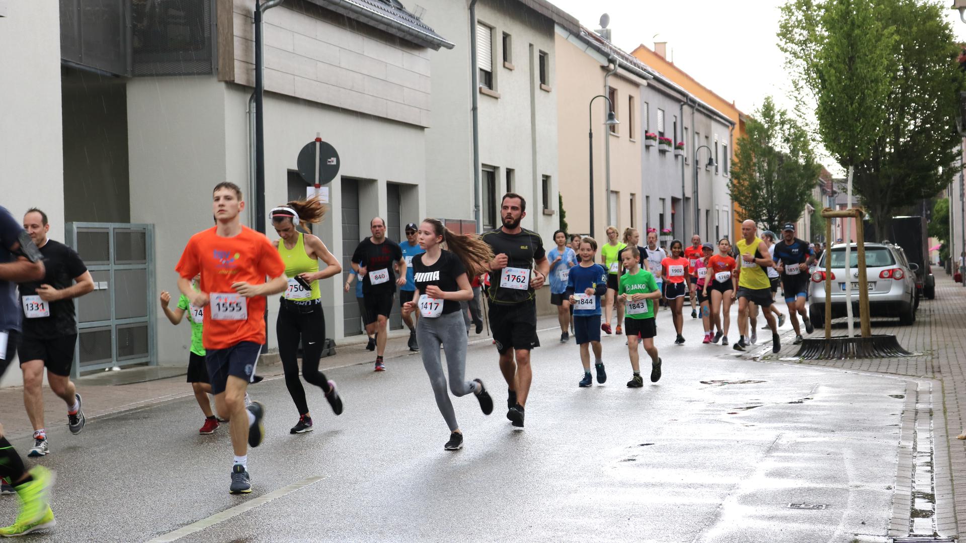 Läufer laufen auf Dorfstraße im Regen