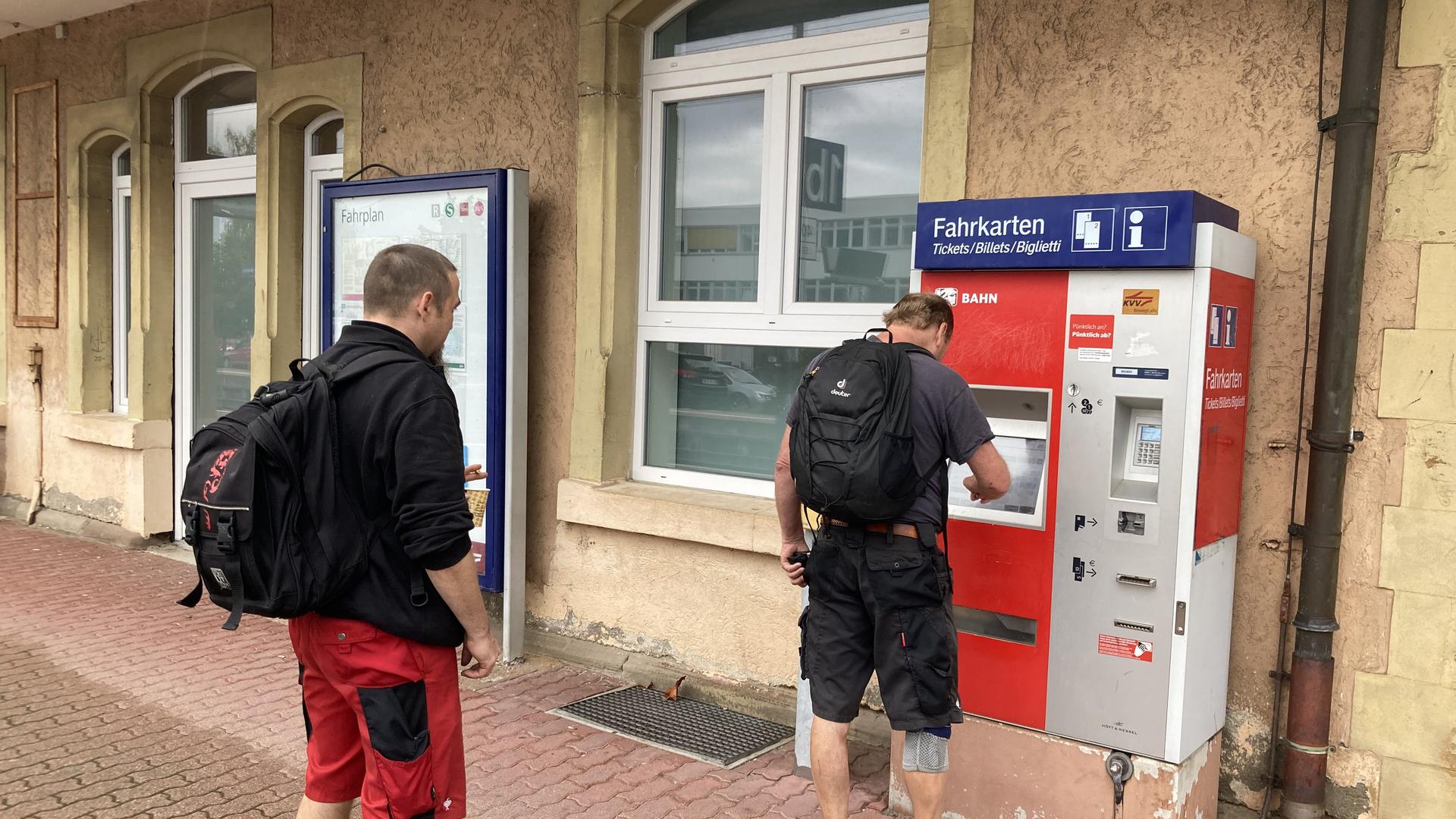 Zwei Männer an Fahrkartenautomat.