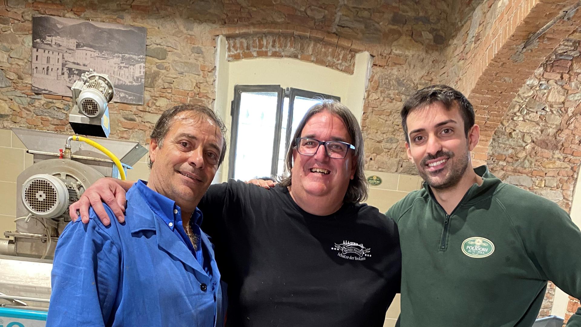 Killermichel“ Michael Reiner mit Alessandro (l.) und Manrico Polidori in deren Ölmühle, wo die frisch geernteten Oliven sofort zu feinstem Öl verarbeitet werden.