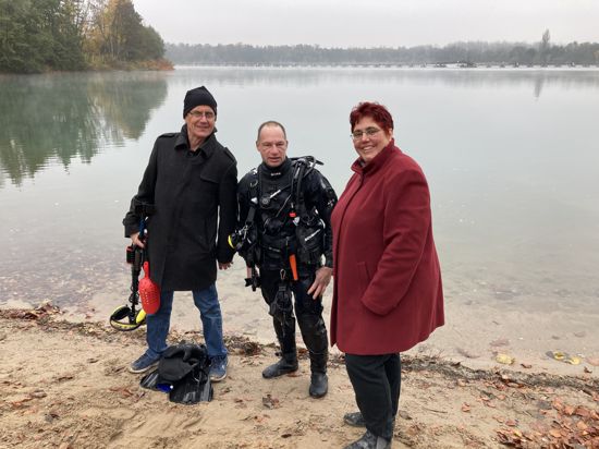 Ringjäger Pascal Michel (Mitte) hat im Weingartener Baggersee nach einem Ehering gesucht – leider erfolglos. Den hatte Rudi May (links) bei einem Besuch am See mit seiner Frau Gabi Spether-May (rechts) vor zehn Jahren beim Schwimmen verloren.