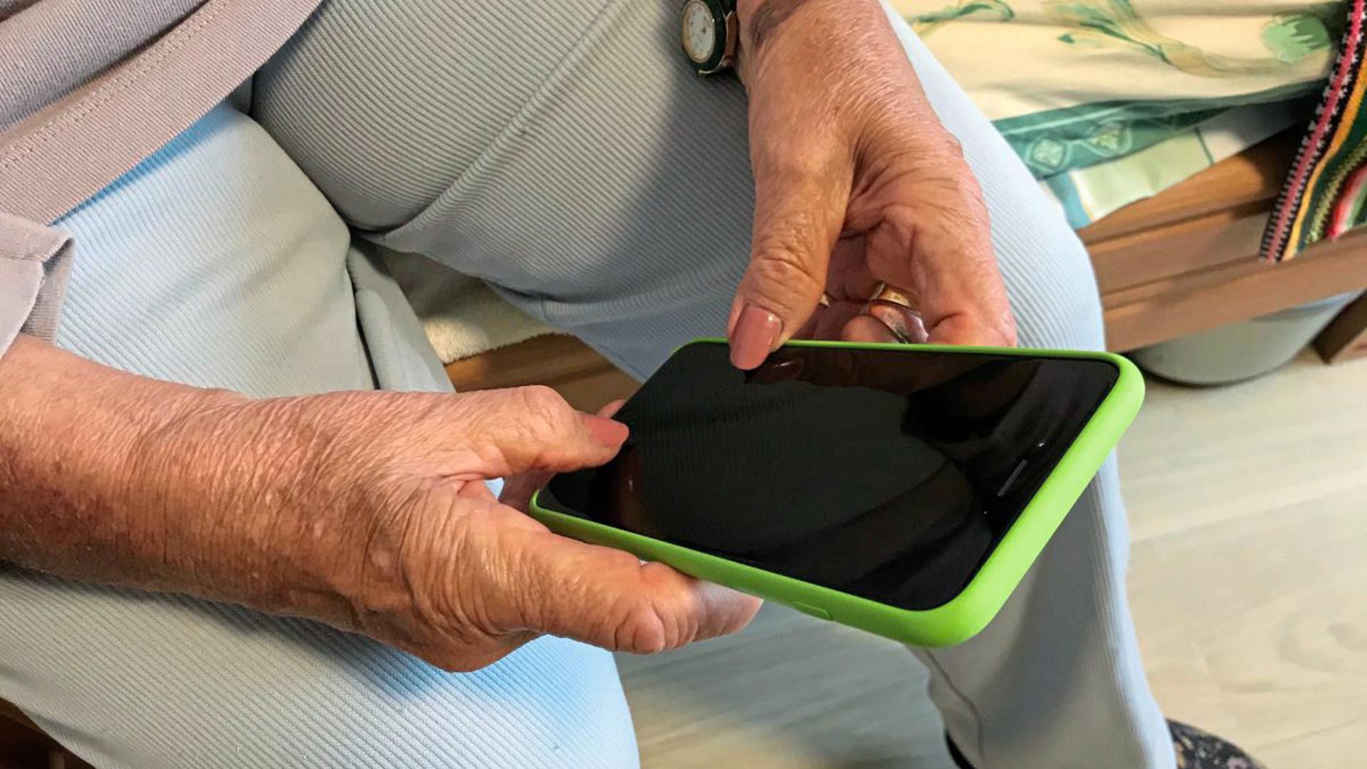 Rosemarie Erb hält ihr iPhone in der Hand. Die 84-Jährige wohnt im Pflegeheim "Alte Mälzerei" in Karlsruhe.