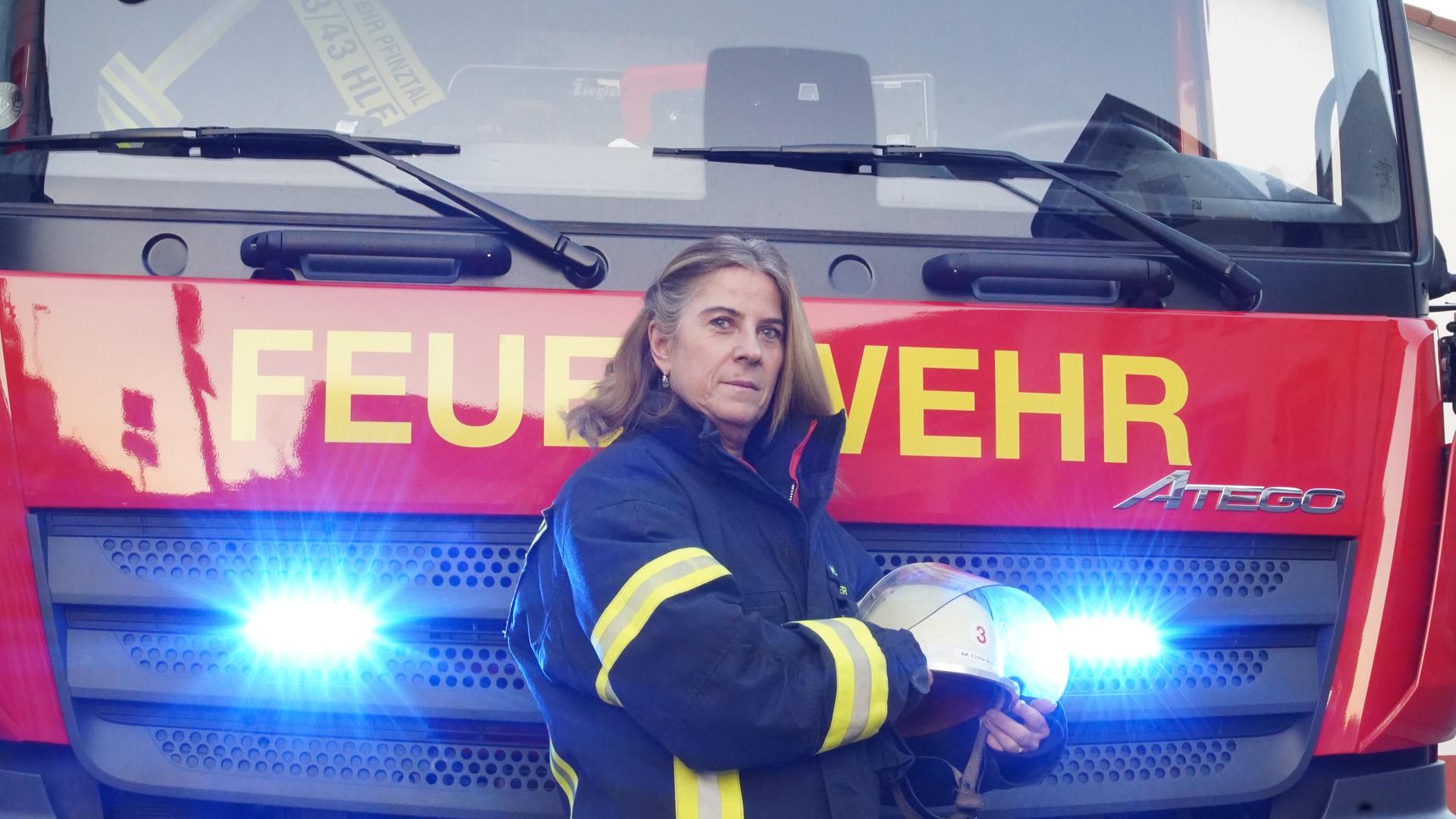 Feuerwehrfrau vor Einsatzwagen