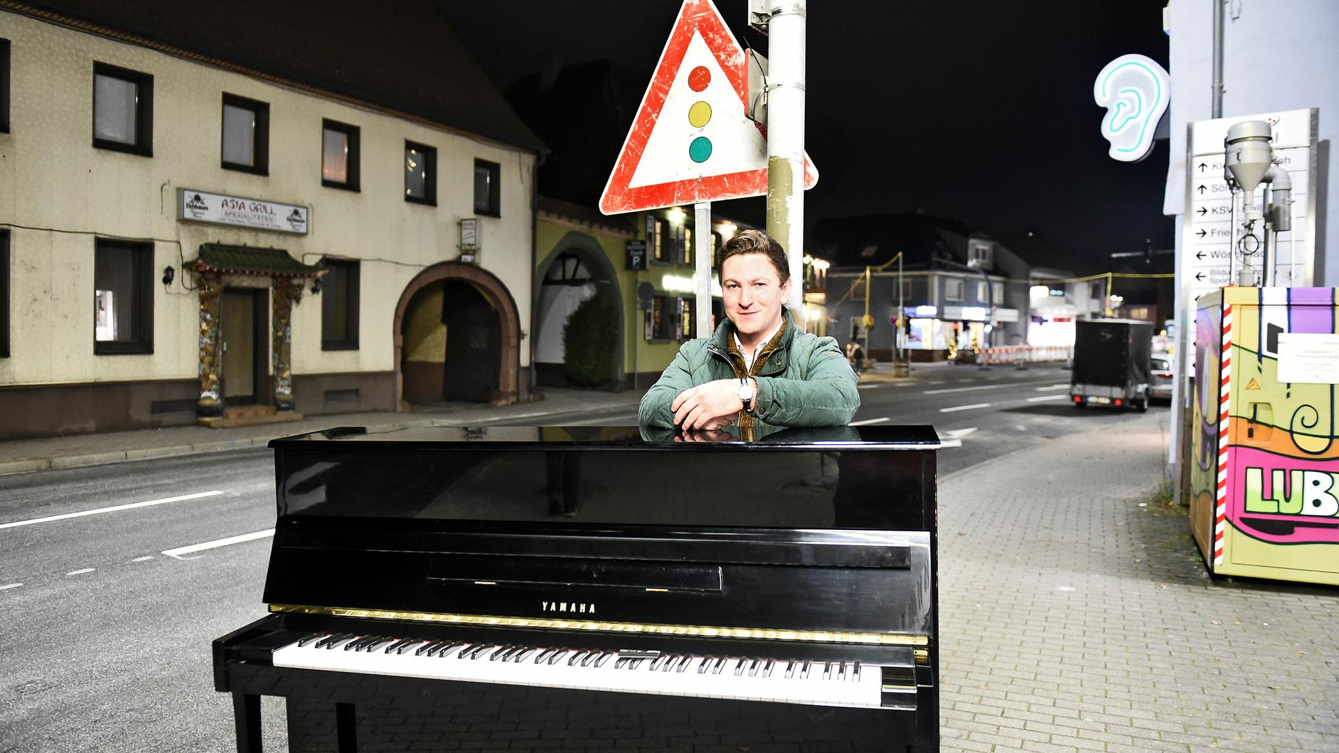 Mann steht hinter Klavier bei Dunkelheit an Bundesstraße